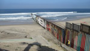 border wall stretching into the sea in Tijuana