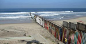 border wall stretching into the sea in Tijuana