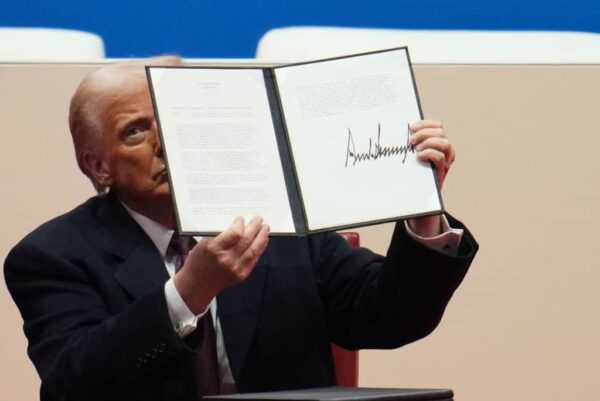 President Trump holds up signed executive order