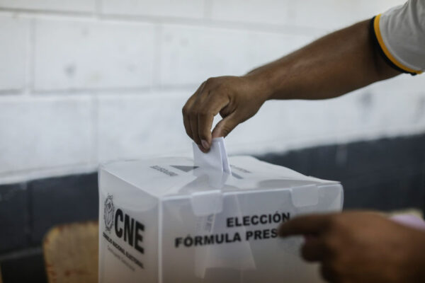 Hand places vote in voting box