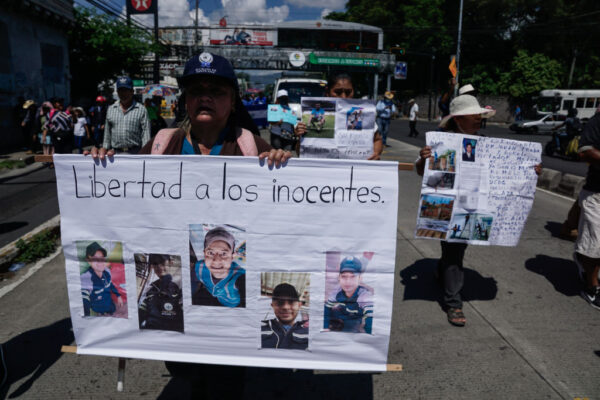 woman holds sign in El Salvador demanding freedom for innocents
